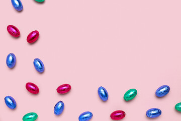 Chocolate Easter eggs in foil on pink background