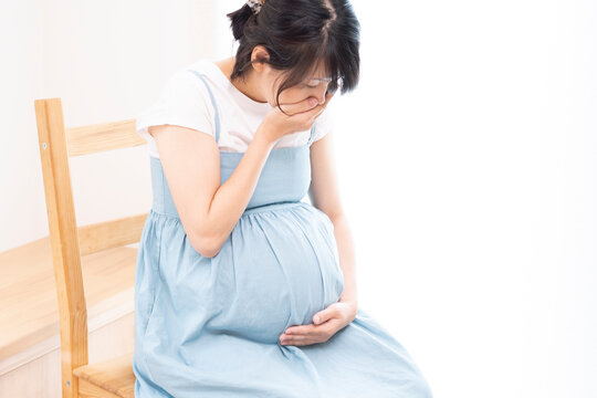 Pregnant woman covers her mouth due to morning sickness
