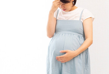 Pregnant woman wearing a blue dress bears the pain