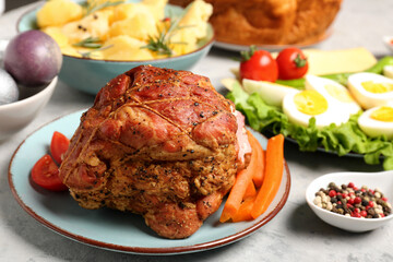 Plate with tasty ham and dishes for Easter dinner on table, closeup