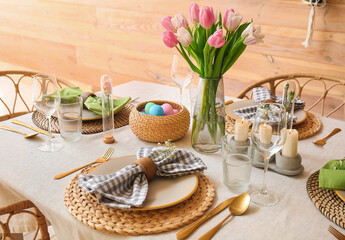 Beautiful Easter table setting with flowers and candles in dining room