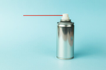 Liquid lubricant in a metal aerosol can on a blue background.