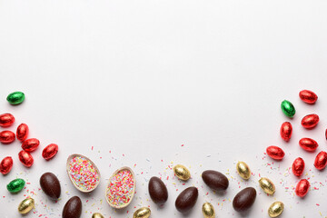 Fototapeta na wymiar Chocolate Easter eggs and sprinkles on white background