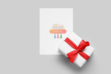 Card for Father's Day with gift on grey background
