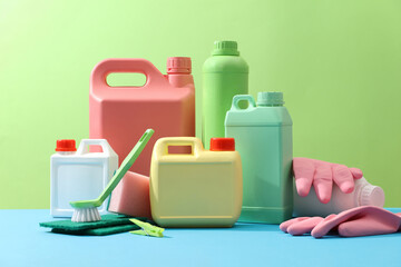 Cleaning products placed on a green background with empty bottles mockup for detergent product,...