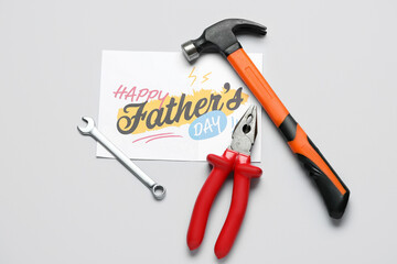 Card for Father's Day with work tools on grey background