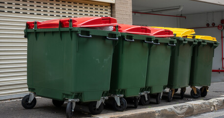 Heavy commercial rubbish bins on street kerbside. Big full garbage trash. Waste management industry...