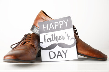 Card for Father's Day with shoes on white wooden table