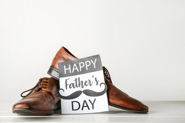 Card for Father's Day with shoes on white wooden table