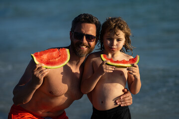 Father and son child eating a tasty watermelon. Father and kid son enjoying watermelon. Father and child son biting watermelon. Summer seasonal fruits and berries for kids. Fathers day.