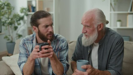 Family conversation on the couch: young and elderly men talk about life, psychological support for each other, cross-generational dialogue, heartfelt consolation, advice and wisdom, warm communication