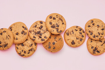 Tasty cookies with chocolate chips on pink background