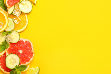 Composition with ice cubes and fresh ingredients for lemonade on yellow background