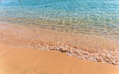 Soft wave of the sea on the sandy beach.