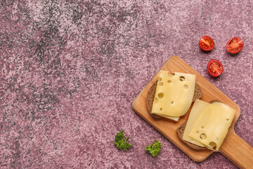 Tasty sandwiches with cheese and tomatoes in board on pink background
