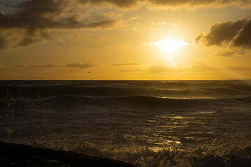 Warm ocean sunset. Sunset dramatic sky on sea. Dreamy fantasy beach, waves splashing. Warm sunlight peaceful, relaxing paradise landscape.