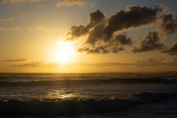Tender ocean sunset. Sunset over the water with birds flying against sunlight on the North Atlantic ocean