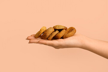 Female hand with tasty dried figs on beige background