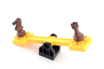 Chess pieces on a seesaw