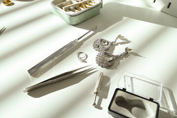 Stylish accessories with tools on table of jeweler in workshop