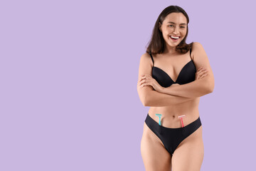 Obraz premium Beautiful young happy woman with razors on purple background
