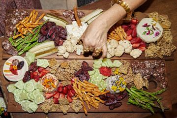 vegan snack board with hand grabbing food