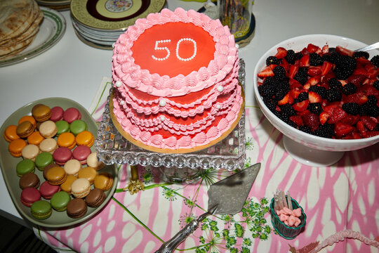 Pink and red 50th birthday cake and dessert spread