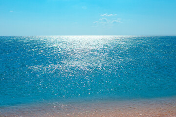 Calm blue sea sparkles illuminated by the sun, seascape