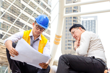 Engineer and foreman worker checking project at building site, Engineer and builders in hardhats...