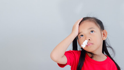 little Asian girl holding forehead feel sick and sneeze with tissue paper on nose - obrazy, fototapety, plakaty