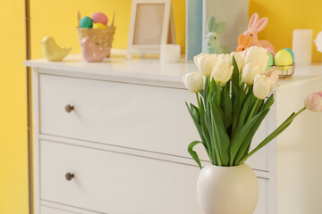 Vase with tulips in room, closeup. Easter celebration