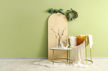 Interior of living room with Easter wreath, table and armchair - obrazy, fototapety, plakaty