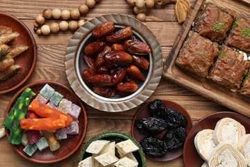 Composition with traditional Eastern sweets and tasbih for Ramadan on wooden table