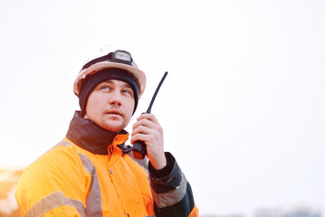 An Offshore Foreman With A Portable Radio Station In The Hand. Seafarer Communicating Using A VHF Radio Station. Communication At Sea During Distress. Project Manager Supervising The Ongoing Loading.	