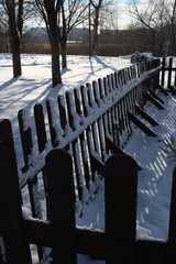 wooden fence in the snow in winter in the park