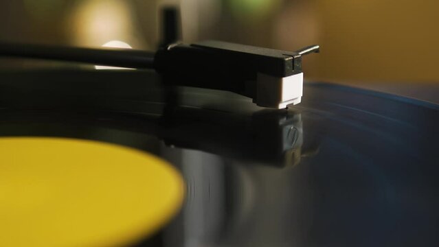 Close Up of the Headshell of a Record Player while a Vinyl is Spinning