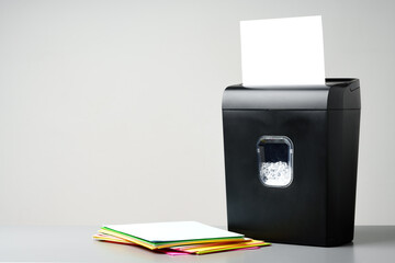 Office paper shredder on table against gray background