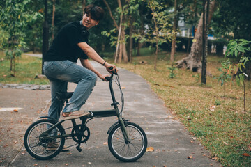Young handsome bearded man taking a break while travelling the city with his bicycle using his...