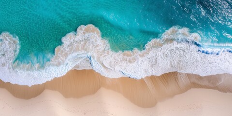 Sandy beach aerial view, with soft beige sand and waves of blue