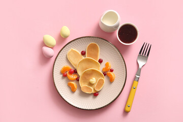 Funny Easter bunny pancakes with mandarin and berries on pink background