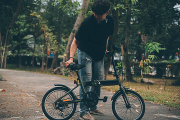 Naklejka premium Young handsome bearded man taking a break while travelling the city with his bicycle using his digital tablet looking away thoughtfully
