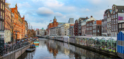 Obraz premium The scenic view of the buildings and canal in the city of Amsterdam in Netherlands