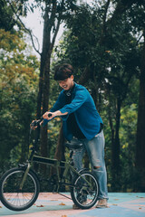 Obraz premium Young handsome bearded man taking a break while travelling the city with his bicycle using his digital tablet looking away thoughtfully