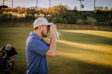 Sotogrante, Spain - January 25, 2024 - The man is using a rangefinder on a golf course.