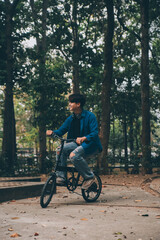 Young handsome bearded man taking a break while travelling the city with his bicycle using his digital tablet looking away thoughtfully