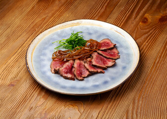 Veal roast beef in a plate on a wooden background
