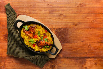Baking dish of traditional chicken biryani on wooden background
