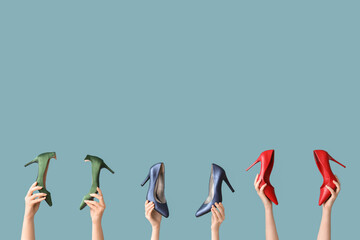 Women with stylish high-heeled shoes on blue background