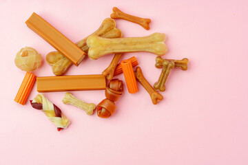 Dog chew bone and sticks on pink background