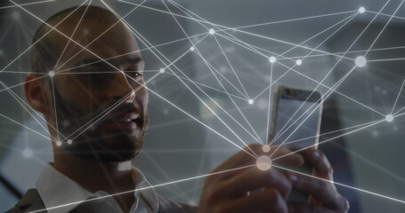 Image of network of connections over caucasian businessman using smartphone